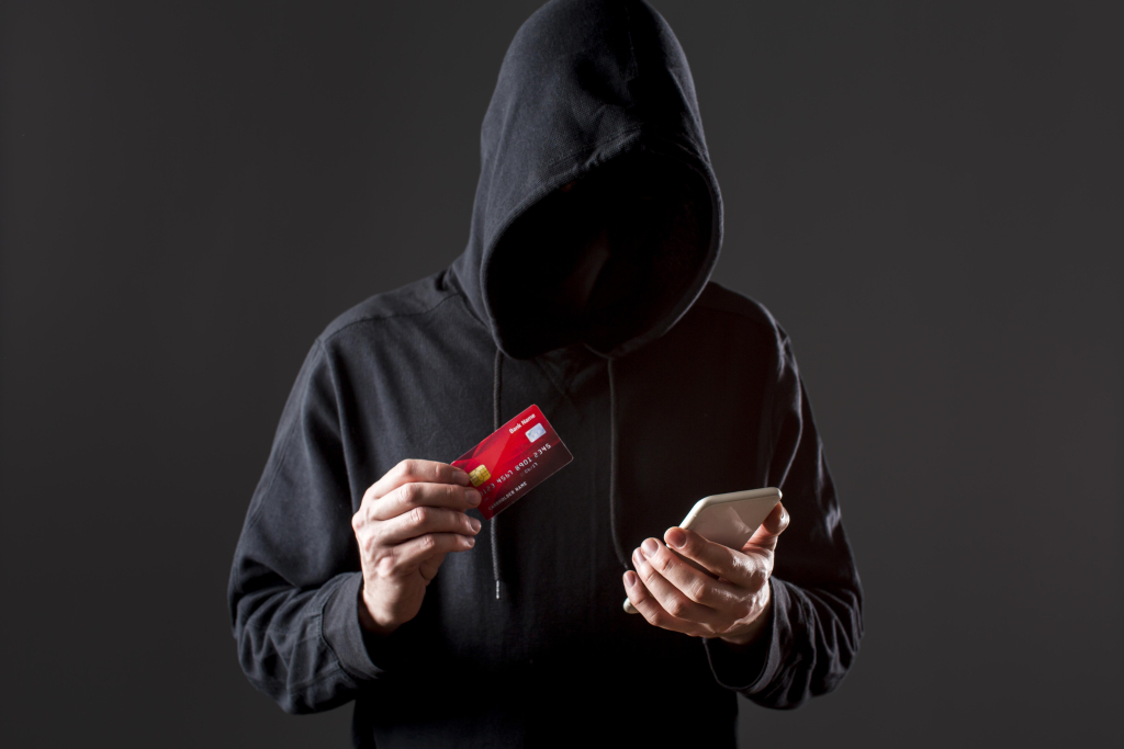 front-view-male-hacker-holding-smartphone-credit-card.jpg