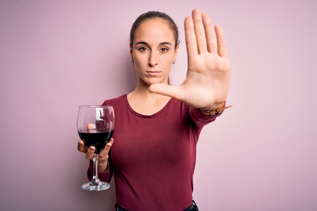 young-beautiful-woman-drinking-glass-with-red-wine-isolated-pink-background-with-open-hand-doing-stop-sign-with-serious-confident-expression-defense-gesture.jpg