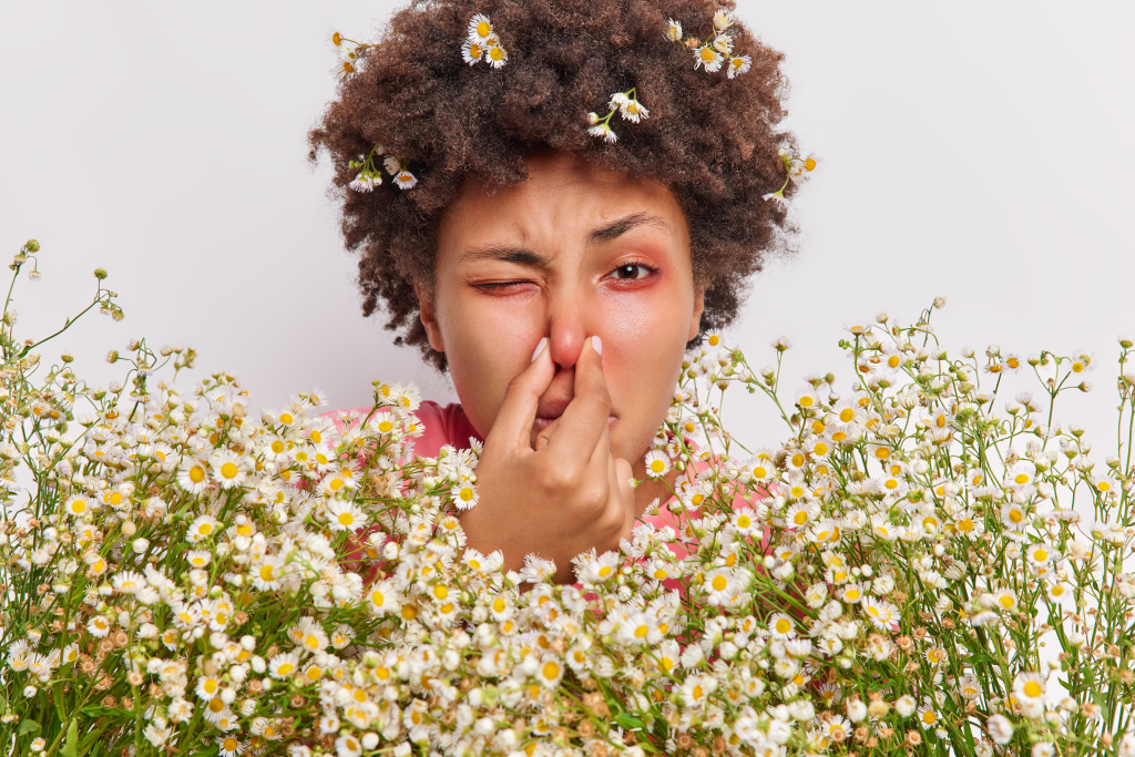 woman-has-problems-with-breathing-holds-nose-suffers-from-allergy-camomile-holds-big-bouquet-flowers-has-red-itchy-eyes.jpg